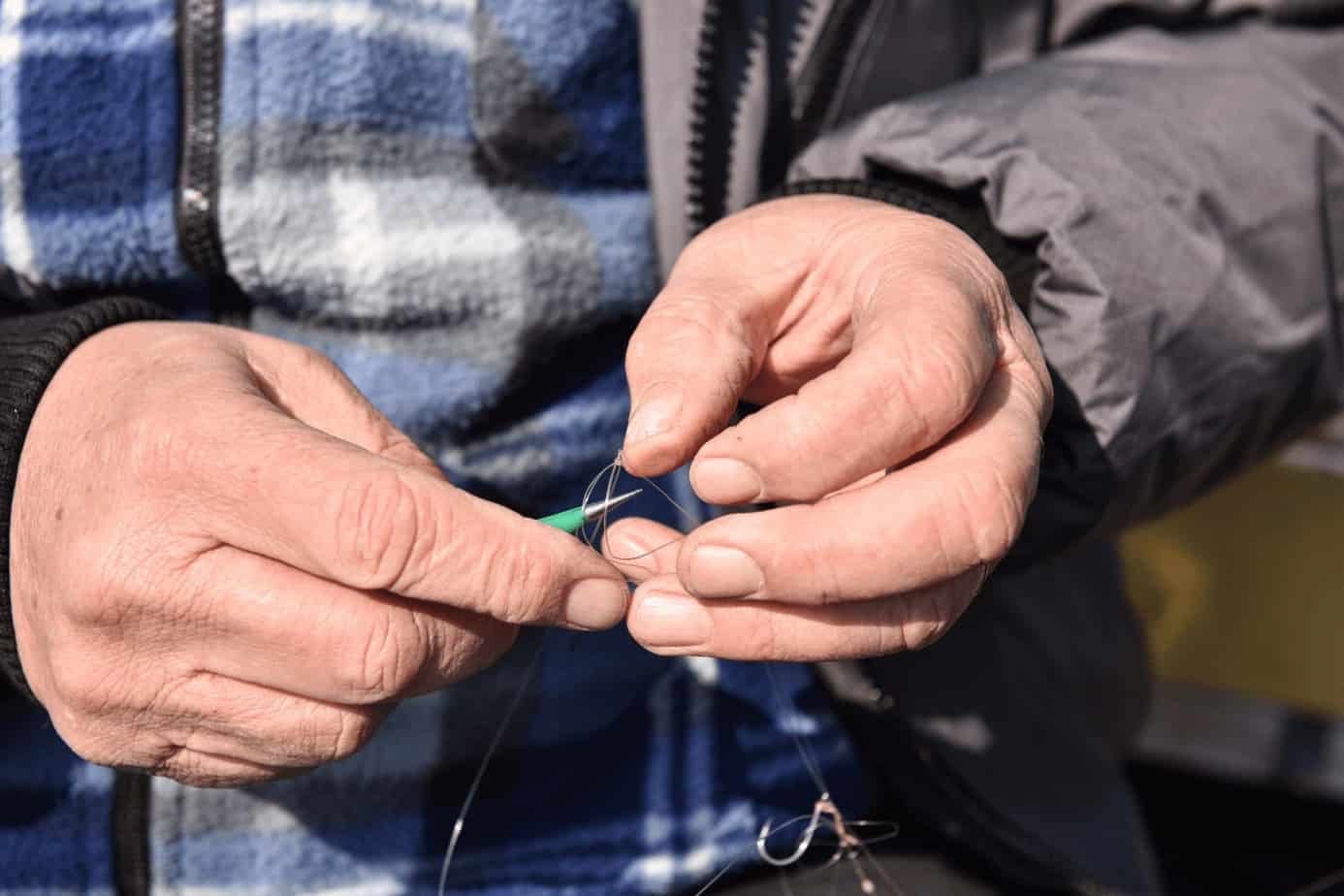 a close-up shot of a man's hand untying a knot