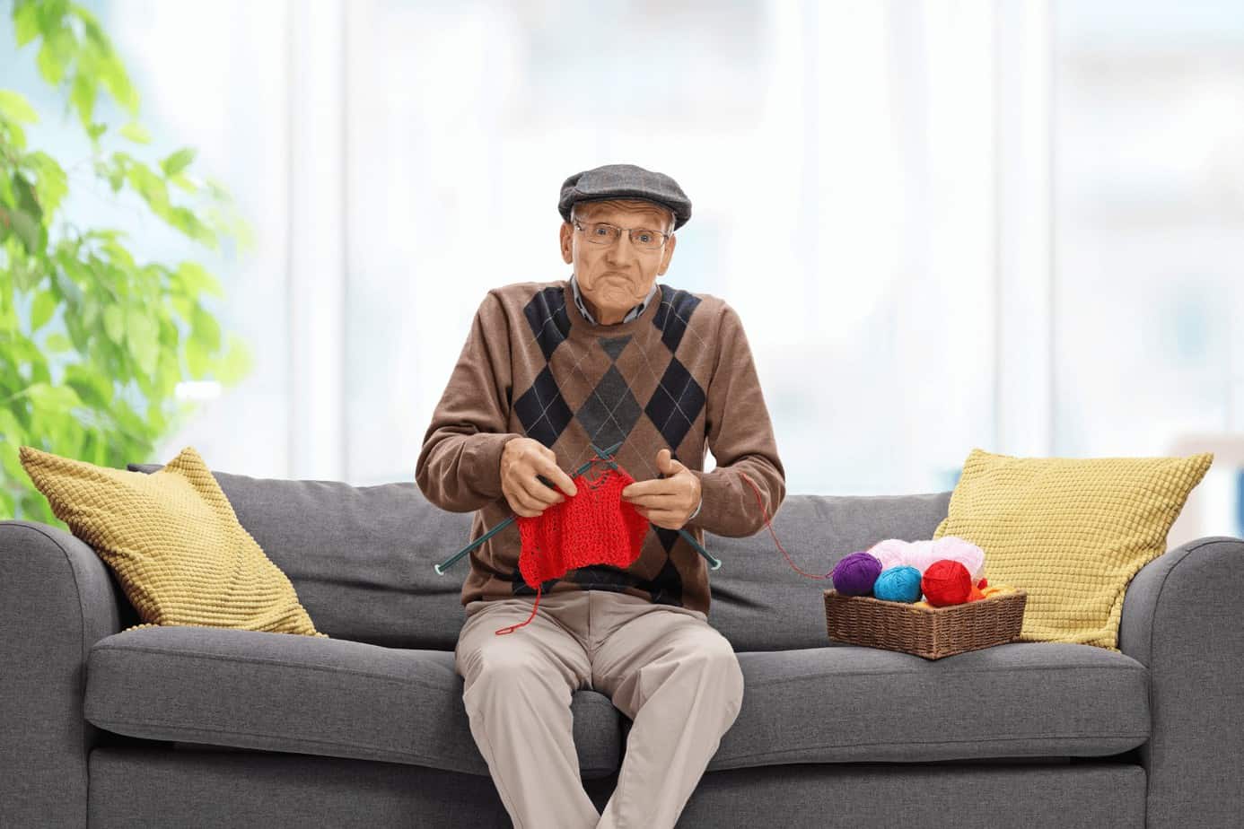 a man with a hat knitting red handkerchief