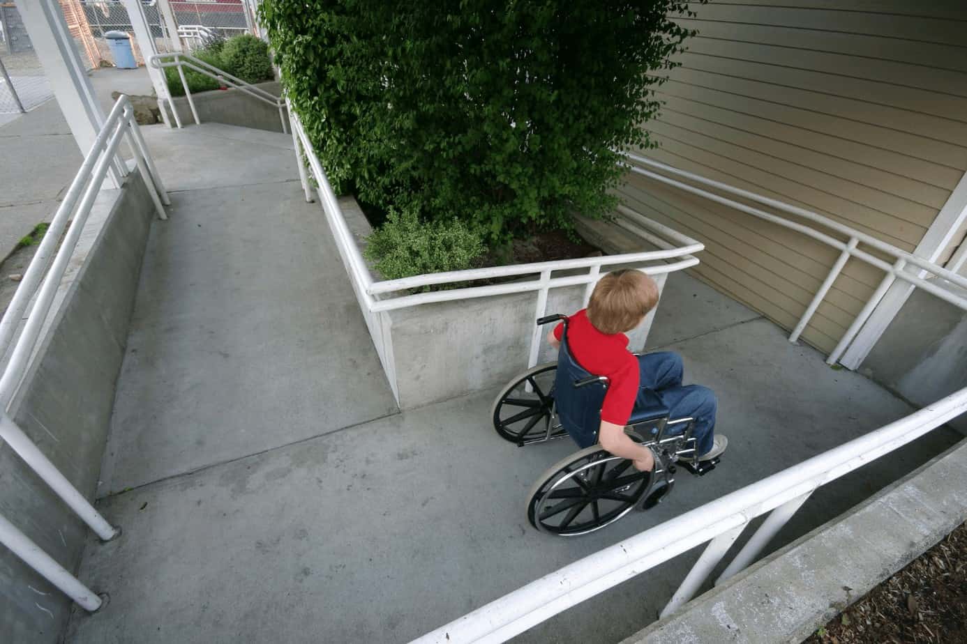 little boy using passing a wheelchair ramp