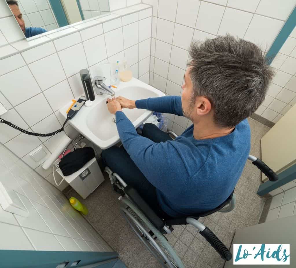 man in a wheelchair washing his hands