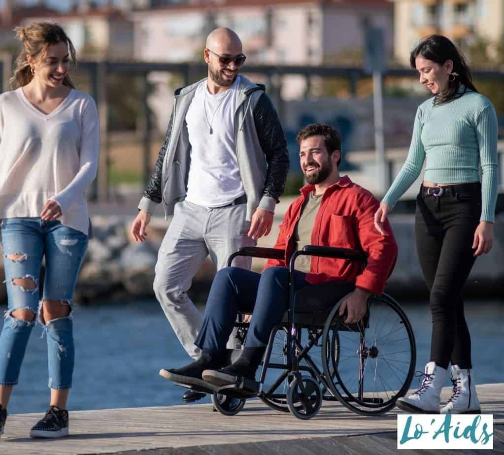 man in a wheelchair strolling with his friends