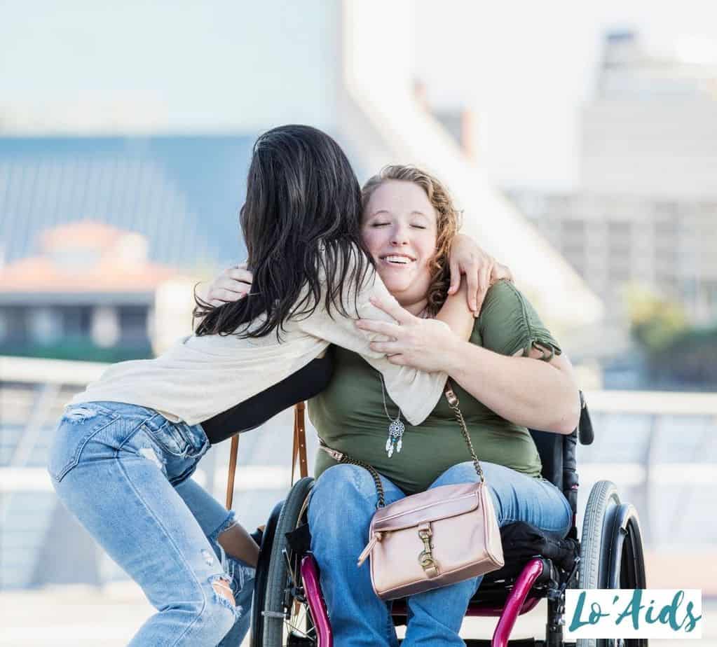 lady embracing her friend in a wheelchair, one of the perks in being in a wheelchair is having nice people around