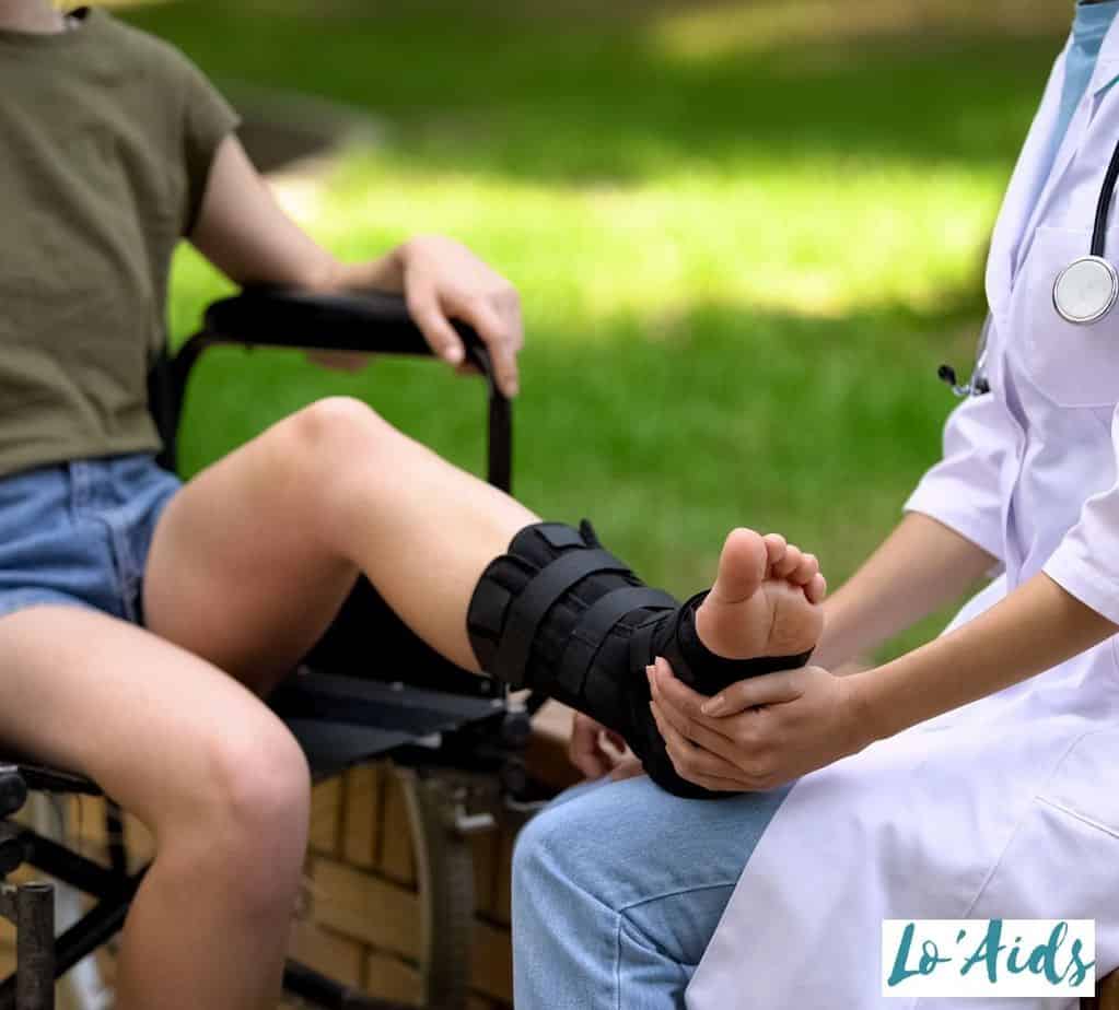 doctor checking the lady's feet with an ankle brace