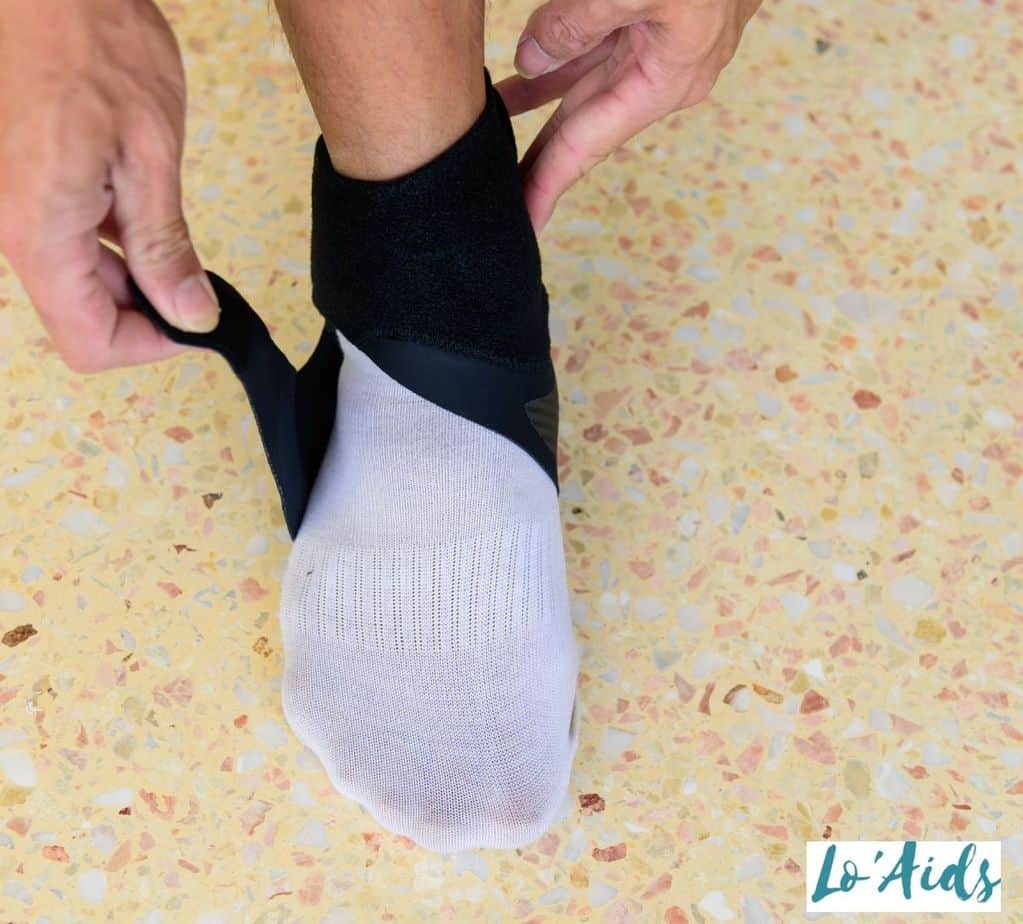man putting on an ankle brace to his right foot
