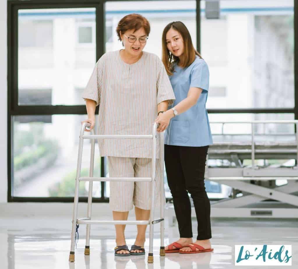 nurse assisting the woman to walk using the standard walker
