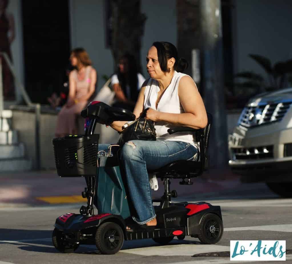 a women on a lightweight mobility scooter outside