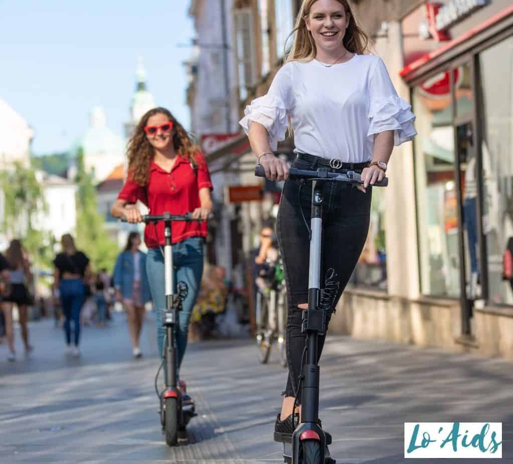 two ladies enjoying riding their electric scooters