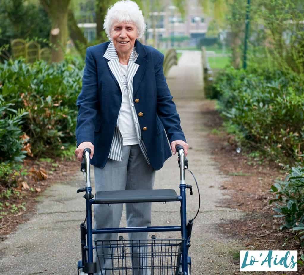 An elderly lady walking in the park with an upright walker