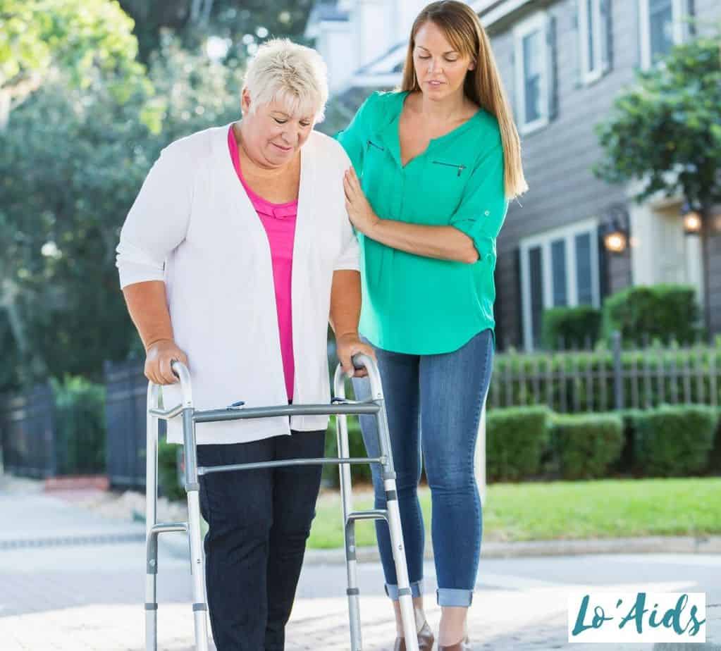 lady assisting a senior woman who uses a walker