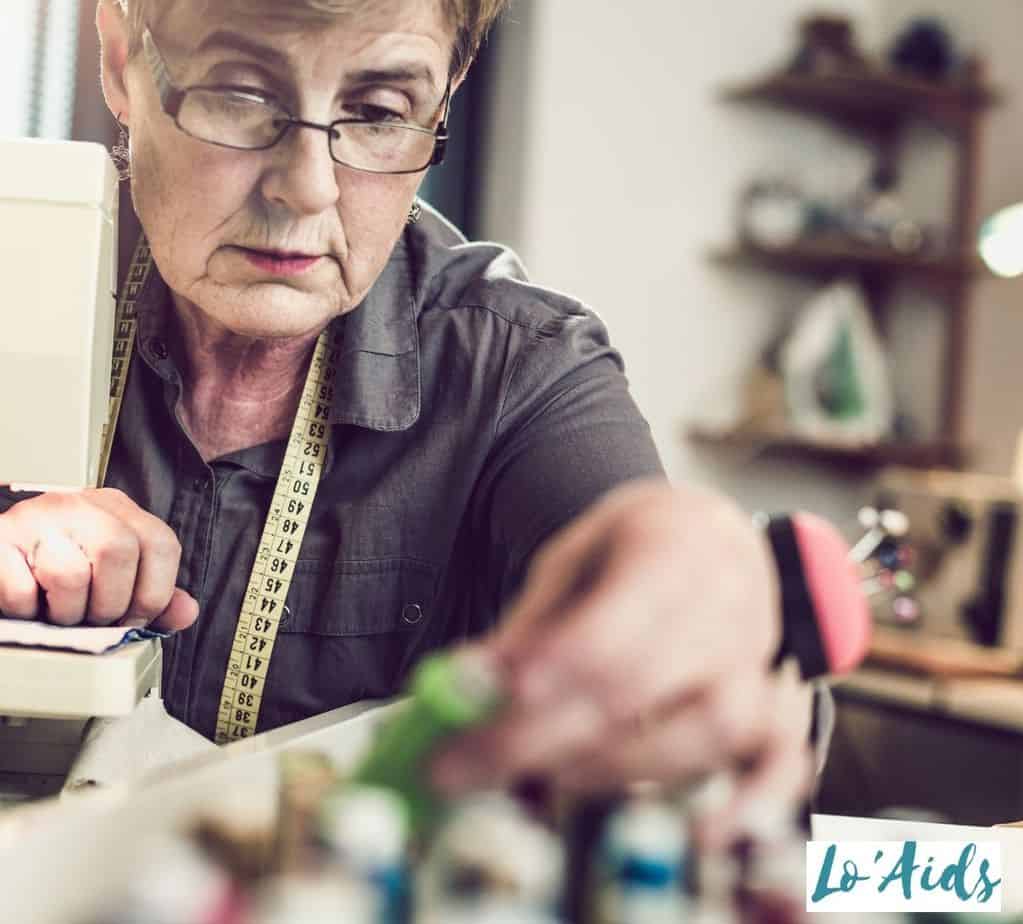 an elderly lady using a sewing machine to encourage fine motor skills in people with Parkinson's disease 