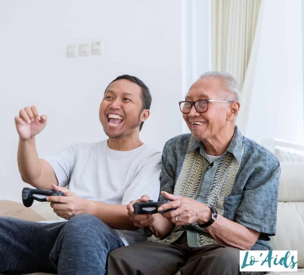 senior playing video games with his son