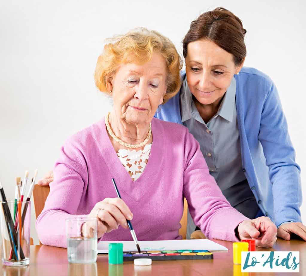 woman teaching the senior on how to paint