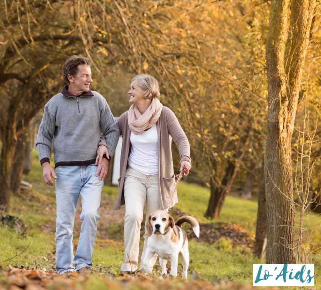 senior couple walking a dog