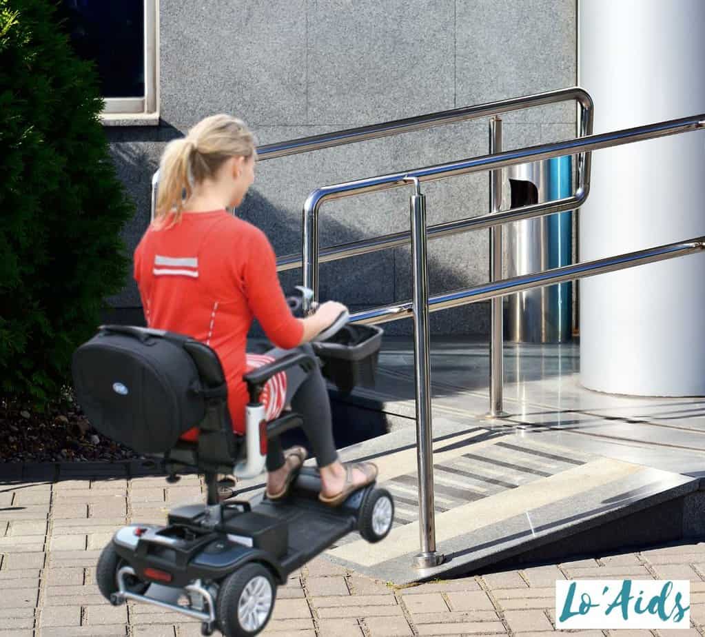 women on mobility scooter climbing up a wheelchair ramp