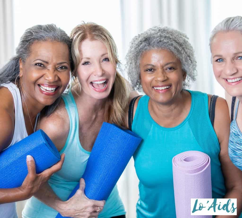 group of senior women holding yoga mats for their class