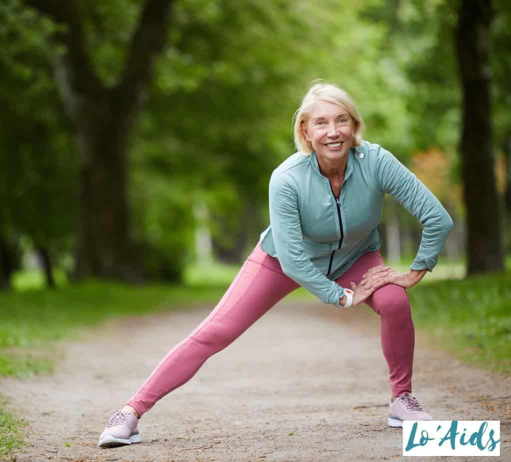 senior woman gently stretching at the park